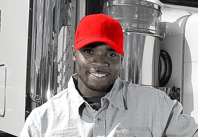 Truck driver standing beside a transport truck