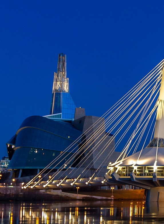 Exterior of the National Museum of Human Rights in Winnipeg, Manitoba, along the waterfront at night.